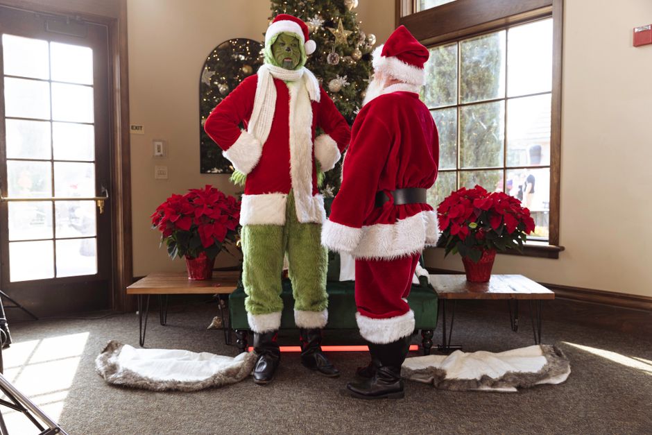 Santa Claus and the Grinch together by a Christmas tree